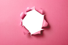 穴の空いたピンク色の紙の背景テクスチャー