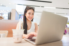 Beautiful woman freelance digital nomad job woman sitting indoors cafe with laptop