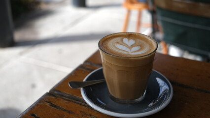 A cup of coffee latte on a wooden table.