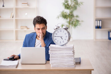 Wall Mural - Young male employee in time management concept