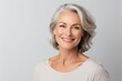 © Liaisan - Smiling middle aged Caucasian woman on white background. Luxurious middle-aged woman with a short grey hair on white background. Woman looking at camera.