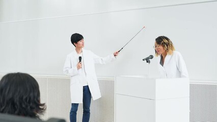 Poster - 教室で研究発表する多国籍グループ