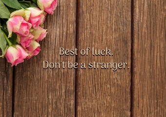Wall Mural - composite of best of luck, don't be a stranger text with pink flowers on wooden table