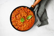Meat tomato sauce in pan bolognese on marble surface food top view