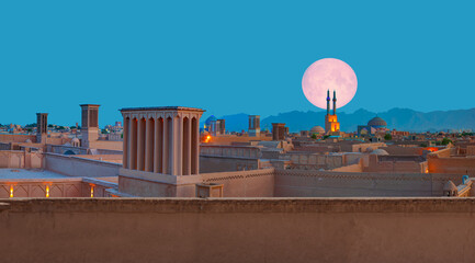 Wall Mural - Historic City of Yazd with famous wind towers in the background full moon and stary sky at twilight blue hour- YAZD, IRAN 