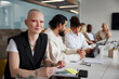 © Johnér - Woman sitting during business meeting and looking at camera