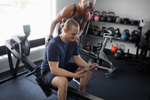 Man And Woman Looking At Digital Tablet In Gym