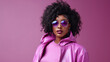 Fashion young african girl black woman wear stylish pink glasses clothes looking at camera isolated on party purple studio background