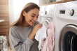 Young woman smells on freshly washed laundry - stock picture