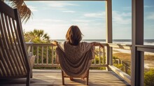 Young Woman Relaxing On The Porch Of A Beach House - Stock Picture