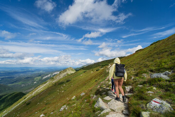 people go hiking in the tatra mountains in poland on a summer day.