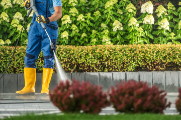 Man Pressure Washing Driveway Using Modern Pressure Washer