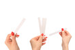 Woman hand with red nails with test strips for the perfume, isolated on a white background.