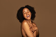 © Prostock-studio - Attractive millennial black woman covering her breast and laughing