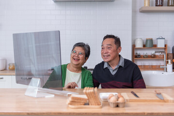 Happy Asian senior couple talking with video calling in the room