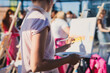 © tsuguliev - Process of drawing, group class of talented students with painting easels and canvases during lesson of watercolour painting outdoors, drawing class for adult artists in art school