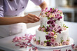 Pastry chef decorating an intricate wedding cake with delicate flowers.