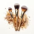Golden makeup brushes on white background