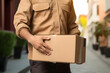 Delivery person in a uniform ringing a doorbell with a package in hand.