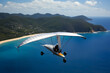 Enthusiasts hang gliding over picturesque coastal towns and sandy beaches.