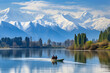 Nature lovers taking a tranquil boat ride on a mirror-like lake surrounded by snow-capped mountains.
