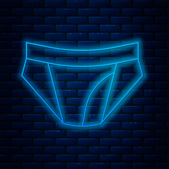 Poster - Glowing neon line Men underpants icon isolated on brick wall background. Man underwear. Vector