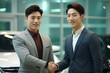© yj - MZ 세대 고객의 취향을 잘 파악할 줄 아는 20대의 젊은 한국인 자동차 판매 사원과 젊은 고객이 신차 구매 계약을 맺고 자동차 전시 매장 안에서 악수를 나누고 있다