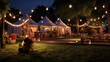 Wesele w ogrodzie - ślub pod namiotami wśród natury wieczorem, nocą oświetlony girlandami i lampami ze ścieżką prowadzącą do namiotu
