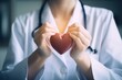Close-up of a doctor cradling a red heart in her hands