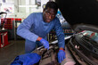© JackF - Professional man car mechanician repairing car in auto repair shop