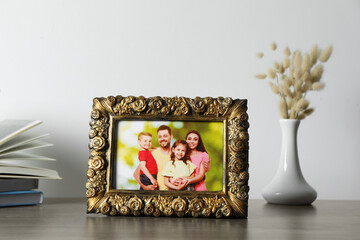 Sticker - Vintage square frame with family photo, books and vase of dry flowers on wooden table