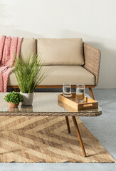 Mid-Century Modern interior living room with tropical style, featuring a rattan wicker lounge chair set and plant decorations. This embodies the concept of a summer living room