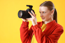 Female Student With Photo Camera On Yellow Background, Closeup