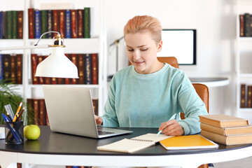 Canvas Print - Female student studying at table in library