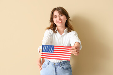 Young woman with USA flag on beige background