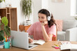© Pixel-Shot - Female student in headphones with laptop doing lessons at home