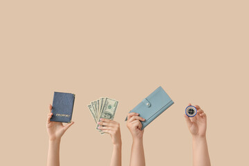 Female hands with passport, money, wallet and compass on beige background. Travel concept