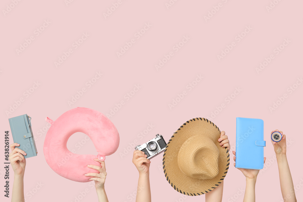 Female hands with cushion, photo camera, hat and compass on beige background. Travel concept