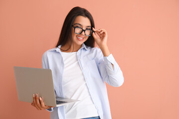 Wall Mural - Happy young female programmer with laptop on orange background