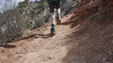 8 Year Old Boy Runs Along Desert Path In Red Rock Mountains Of Escalante Utah