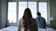 © henjon - A couple sitting on their bed far apart, having serious relationship problems or issues with their sex life. Shallow field of view.