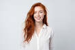© JuanM - Happy attractive young woman with wavy red hair and freckles isolated over white background. Generative AI.