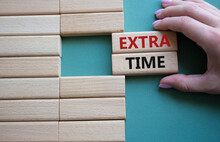 Extra Time Symbol. Concept Word Extra Time On Wooden Blocks. Businessman Hand. Beautiful Grey Green Background. Business And Extra Time Concept. Copy Space