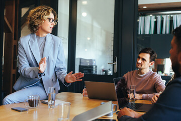 Wall Mural - Female team leader having a discussion with her colleagues in a meeting