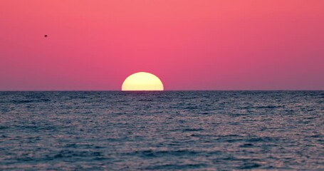 Wall Mural - sun is rising up in color sky clouds over sea horizon 4k video, ocean waves sunrise