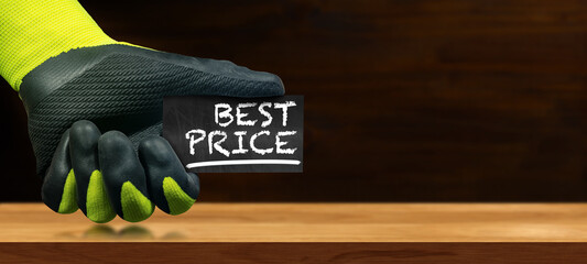 Aufkleber - Hand with protective work glove holding a small blackboard with the text Best Price written in chalk, on a blank wooden workbench with copy space and reflections.