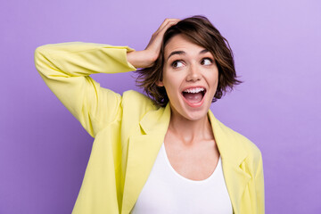 Portrait of funny interested girl bob brown hair wear yellow glamour suit hand touch head crazy news isolated on purple color background