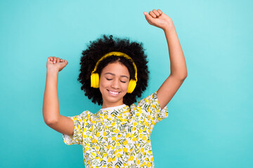 Wall Mural - Photo of carefree cheerful girl dressed stylish clothes raising hands dancing having fun good mood isolated on cyan color background