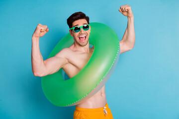 Canvas Print - Photo portrait of attractive young man raise fists excited float circle dressed stylish yellow shorts isolated on blue color background