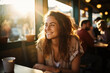 © ekim - Smiling young woman sitting in cafe with her friends. Warm sunlight through window lights her hair and face. Happy lifestyle. Bokeh background.